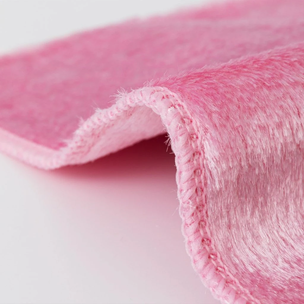Wood fiber dishwashing cloth with hemmed edges for reusable grease cleaning.